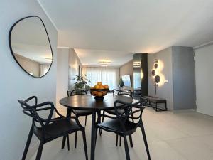 a dining room with a table and chairs and a mirror at Luxury Sea View - PANORAMA MAR- PUNTA PRIMA by GrupoQuattro in Punta Prima