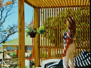 Revival House Shalom في خليج جيفريز: امرأة تقف على شرفة مع نباتات في أصص