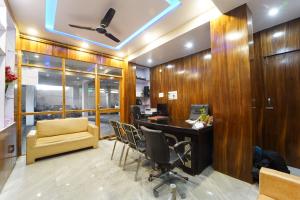a office with a desk and chairs in a room at Sharsh Banquet and Hotel in Patna