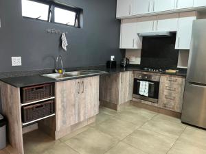 a kitchen with a sink and a refrigerator at The Eyrie in Nelspruit