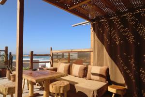 a wooden table and chairs on a patio with a view of the ocean at hyle Surfhouse in Agadir