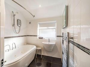 ein weißes Badezimmer mit Badewanne und Waschbecken in der Unterkunft 4 Bed in Rosthwaite 86248 in Rosthwaite