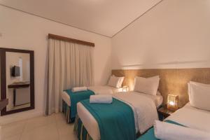 ein Hotelzimmer mit zwei Betten und einem Spiegel in der Unterkunft Pousada da Villa in Fernando de Noronha