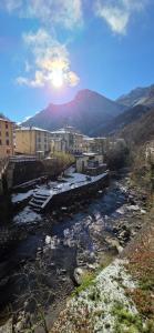 a river with buildings and mountains in the background at Il Borgo By Phoenix in Olmo al Brembo