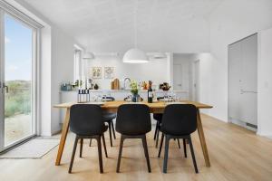 une cuisine avec une table et des chaises en bois dans l'établissement 1305-Snedsted-Klitfogedvej-5, à Snedsted