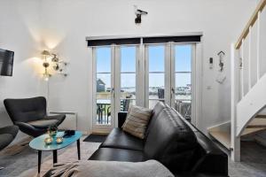 a living room with a leather couch and a table at 254-Vestervig-Havnevej-1-lejl-4 in Vestervig