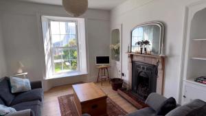 een woonkamer met een bank en een open haard bij Victoria Residences in St Ives