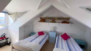 twee bedden in een kamer met een zolder bij Victoria Residences in St Ives