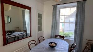 een eetkamer met een tafel en een spiegel bij Victoria Residences in St Ives +5 foto's