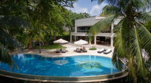 uma piscina em frente a uma casa em Almanara Luxury Boutique Hotel and Villas em Praia de Diani