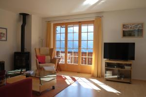 TV a/nebo společenská místnost v ubytování Höhwald 2 Alpenapartment mit Berg & Seeblick by Arosa Stay