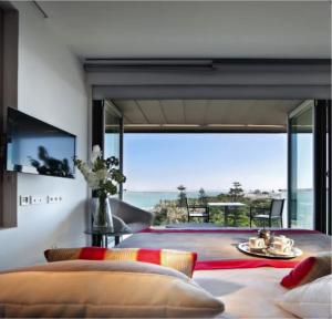 een slaapkamer met een groot raam met uitzicht op de oceaan bij Rompe Olas in Maitencillo