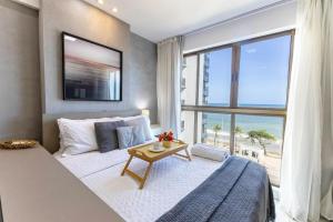 レシフェにあるBnb Flex Suitesのビーチの景色を望むベッドルーム1室(ベッド1台付)