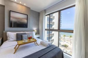 レシフェにあるBnb Flex Suitesのベッドと大きな窓のある寝室