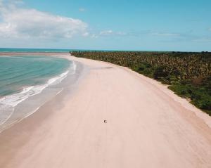 a white sandy beach with the ocean and the sky at Casa Amaré - Moreré in Moreré