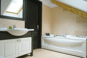 a bathroom with a sink and a tub and a mirror at Mi Chalet - Poiana Izvoarelor in Vatra Dornei