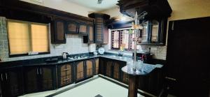 a kitchen with wooden cabinets and a marble counter top at 1 navarethna Villa in Trivandrum