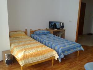Cette chambre dispose de 2 lits et d'un bureau avec une télévision. dans l'établissement Elias Apartment, aux Sables d'or