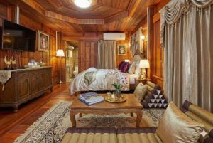 Un dormitorio con una cama, un sofá y una mesa. en Wellness Resort Rayong Managed by the SCN resort and spa limited, en Ban Huai Pla Kang