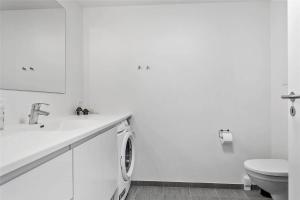 a white bathroom with a washing machine and a toilet at 784-Thisted-Havstokken-30-A in Thisted