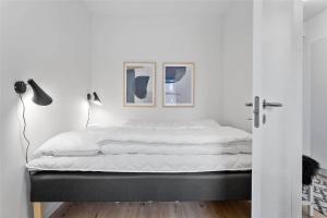 a bed in a bedroom with two pictures on the wall at 784-Thisted-Havstokken-30-A in Thisted