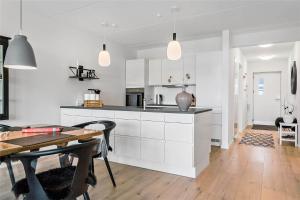a kitchen with white cabinets and a dining table at 784-Thisted-Havstokken-30-A in Thisted