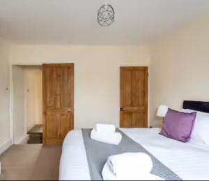 a bedroom with a white bed with purple pillows at Reading retreat in Reading