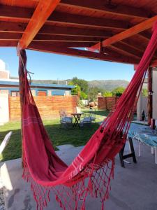 a red hammock hanging from a roof at Cabañas los materos 2 in Córdoba