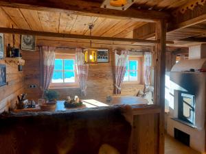 a log cabin kitchen with a large couch in it at Ferienhütte Alpenherz in Alpbach +7 photos