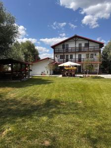 a large building with a grass field in front of it at Casa Carp Calarasi in Călăraşi