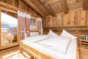 a bedroom with a bed in a room with a window at Ferienhütte Alpenherz in Alpbach