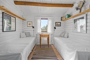 two beds in a room with a table and a window at 309-Bedsted-Thy-Redningsvej-9 in Bedsted Thy