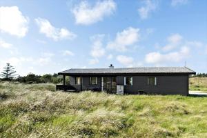 a black house sitting on top of a grassy hill at 309-Bedsted-Thy-Redningsvej-9 in Bedsted Thy