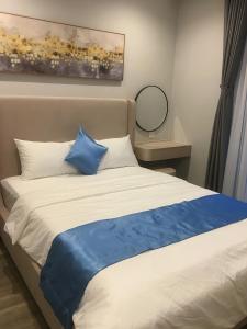 a bed with blue and white pillows in a room at HADU Hotel & Café Phu Quoc in Phú Quốc +29 photos