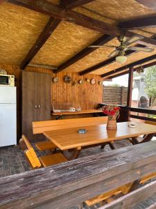a kitchen with a wooden table and a refrigerator at Casa Carp Calarasi in Călăraşi