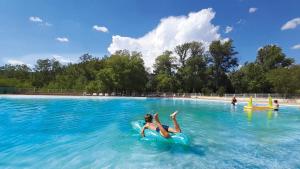 a woman is laying on an inner tube in a swimming pool at Camping Tikayan La Célestine - Maeva in Beynes