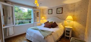 a bedroom with a bed and a window at Pousada Atalaia Premium in Campos do Jordão