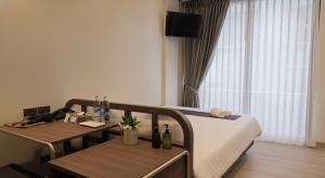 a hotel room with a bed and two tables and a couch at Warm Pillow Hotel Bangkok in Bangkok