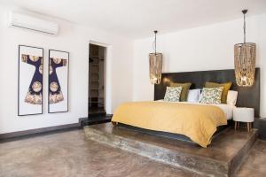 Villa Coconut Oasis في Bain Boeuf: غرفة نوم بسرير كبير وثريات