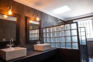 Villa Coconut Oasis في Bain Boeuf: مغسلتين في حمام مع مرآيتين