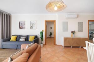 ein Wohnzimmer mit Sofa und Tisch in der Unterkunft 1G Apt Rosmaninho in Santa Luzia