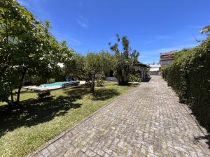 a cobblestone path in a park with a bench at Pepa Kingdom in Matinhos