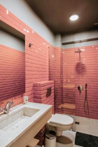 La salle de bains est pourvue de murs en briques rouges, d'une baignoire et de toilettes. dans l'établissement Its Kale Boutique Hotel, à Ioannina