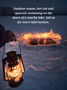 una lanterna nella neve con un cerchio di fuoco di Raanu Apartment 59km from Rovaniemi center a Raanujärvi