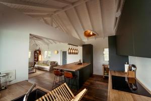 Una cocina y una sala de estar con mesa y sillas. en Ravenala, en Saint Martin