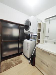 御殿場市にある駅近2分 昭和の家のシンク、電子レンジ、冷蔵庫を備えたキッチン