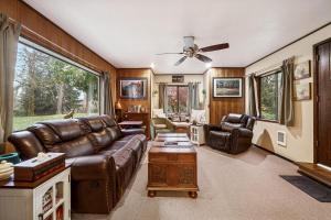 Sasquatch Sanctuary | Hot tub في باكوود: غرفة معيشة مع أريكة جلدية وطاولة