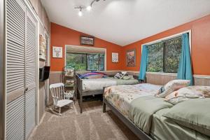 Sasquatch Sanctuary | Hot tub في باكوود: سريرين في غرفة بجدران برتقالية