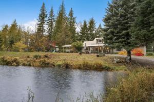 Sasquatch Sanctuary | Hot tub في باكوود: منزل أمامه بركة