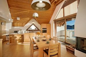 a kitchen and dining room with a wooden ceiling at Komforna planinska kuća za odmor in Mrkopalj +74 photos